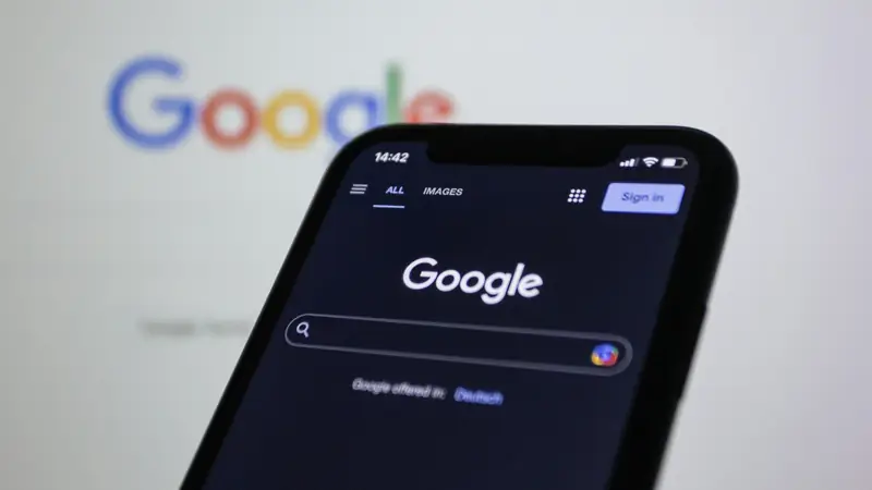 Google's home page on a smartphone, the Google logo blurred in the background