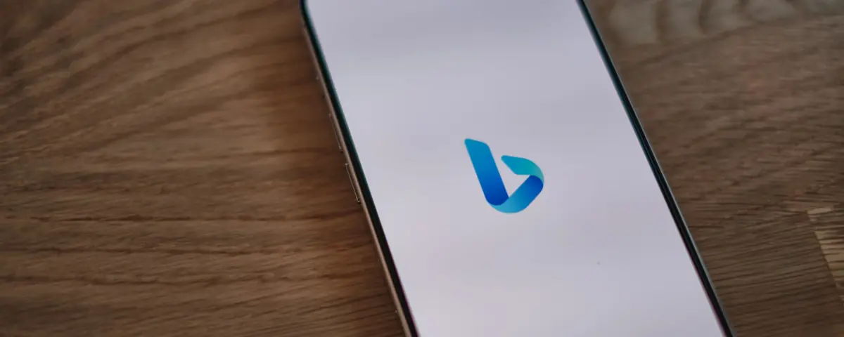 The Bing logo on a smartphone lying on a wooden table